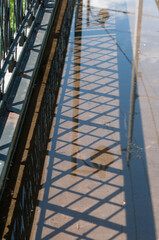 railway bridge in the city (or pool of water with reflection of bridge barrier fence)