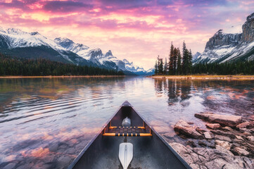 Beautiful view of Spirit island with canoe and dramatic sky on autumn season in the sunset at Jasper national park
