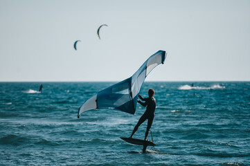 Man using windsurfing wing and a hydrofoil board on the water