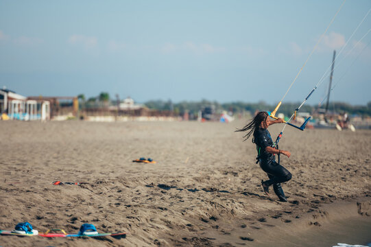 Woman using control bar to lift her kite up for kitesurfing