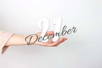 December 21st . Day 21 of month, Calendar date. Calendar Date floating over female hand on grey background. Winter month, day of the year concept.