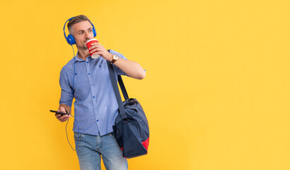 guy chatting in earphones while drinking takeaway coffee. copy space. businessman