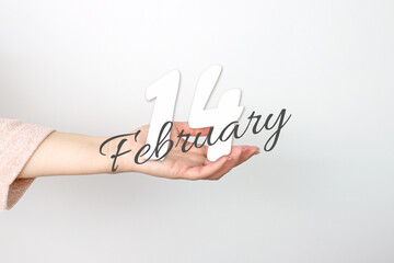 February 14th. Day 14 of month, Calendar date. Calendar Date floating over female hand on grey background. Winter month, day of the year concept.