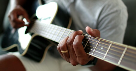 Man practicing with classic guitar at home during leisure time