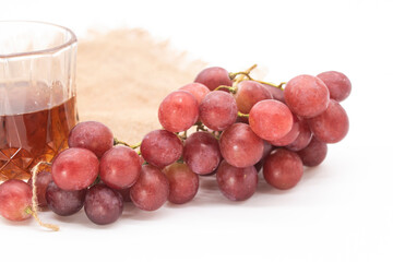 Bunch of red grapes with glass of wine isolated on background