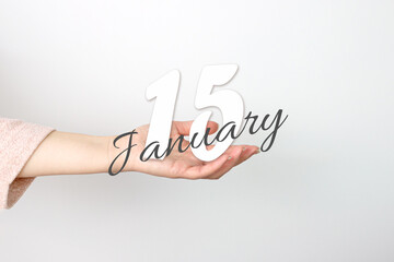 January 15th. Day 15 of month, Calendar date. Calendar Date floating over female hand on grey background. Winter month, day of the year concept.