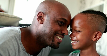 Fototapeta premium Father and son love and affection. Parent kissing and hugging little boy child. Mixed race African ethnicity