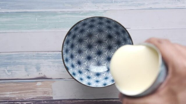 slow motion of pouring condensed milk in a bowl 