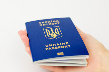 Ukrainian passport in a female hand on a white background, selective focus