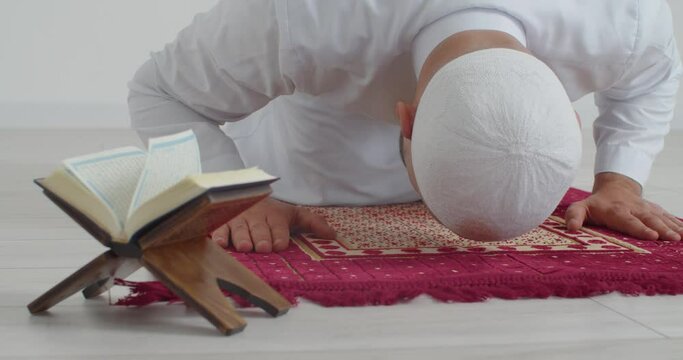 Muslim man praying to Allah in light room