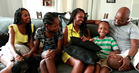 Candid authentic black African family together in living-room sofa