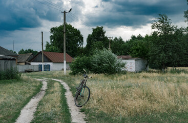 Rusty old bicycle waiting for the rider on the roadside in village of central Ukraine