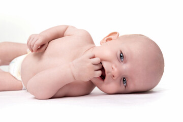 charismatic baby with a smile on his face on a white background puts his fingers in his mouth