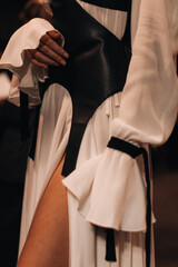Female fashion figure in stylish creative black white outfit on backstage. Vertical fashion shot