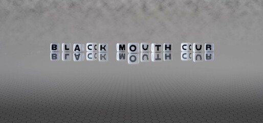 black mouth cur word or concept represented by black and white letter cubes on a grey horizon...