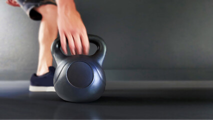 Black cast iron kettlebell on a black background. Black kettle bell with hand