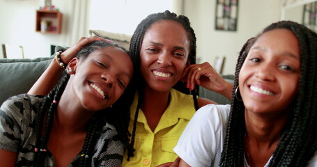 Black mother and teenage daughters posing together. candid real people