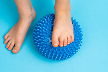 children's feet with a blue balancer on a light blue background, treatment and prevention of flat...
