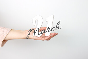 March 21st . Day 21 of month, Calendar date. Calendar Date floating over female hand on grey background. Spring month, day of the year concept.