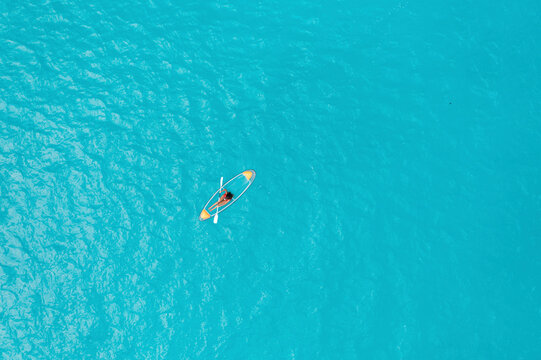 Aerial Top Down View Of Person Kayaking Over Clear Blue Ocean Water In Male, Maldives.