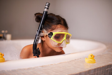 Like a duck to water. Shot of a cute little girl wearing snorkeling gear in the bath.