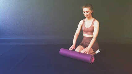 Fitness background for your business. The girl is engaged in pilates on a pink yoga mat. Class Stretching in the gym on a black rubber covering. Exercise stretching cobra. Top view advertising banner.