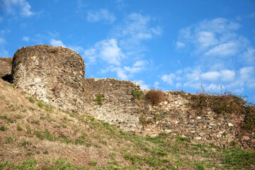 Fortress ancient wall against the background of a blue sky with white clouds. The topic of traveling to historical places in Europe.