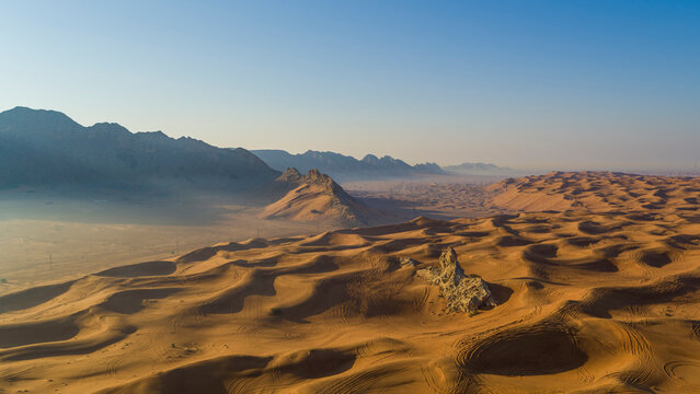 Aerial view of sand dunes near the Sphinx in the desert at sunset, Dubai, United Arab Emirates.