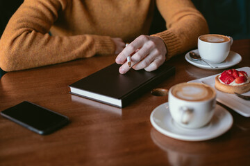 Man working and drinking coffee in a cafe.