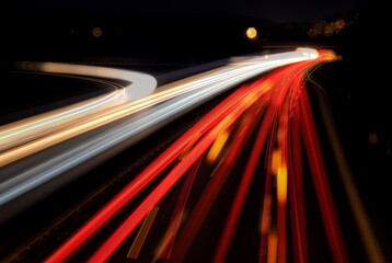 Blurred lights of passing cars on curvedfour lane german “Autobahn“ in Iserlohn town centre...