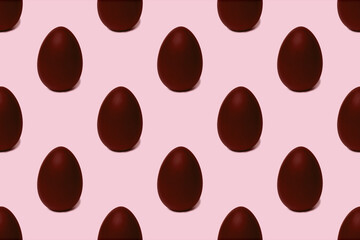 Seamless pattern of whole chocolate Easter eggs on a pink background, tinted. Easter sweet chocolate background