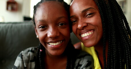 African mother kissing teen daughter child in cheek