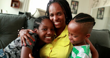 African mother embracing teen daughter and little boy son. African black ethnicity, love and affection
