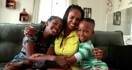 African mother embracing teen daughter and little boy son. African black ethnicity, love and affection