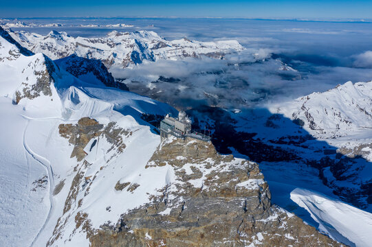 Aerial view of Jungfraujoch, a building on mountain crest with snow on Swiss Alps, Wengen, Bern, Switzerland.