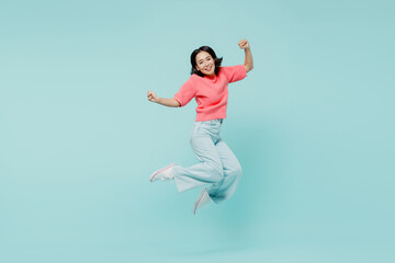 Fototapeta na wymiar Full size young excited happy woman of Asian ethnicity 20s wearing pink sweater jump high do winner gesture isolated on pastel plain light blue background studio portrait. People lifestyle concept