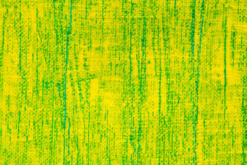 abstract bright colored background: yellow paint on a blue fabric close up, translucent green colo