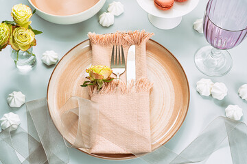 Beautiful and romantic table setting with flowers and ribbons in light pink colors. Holiday table decoration. .