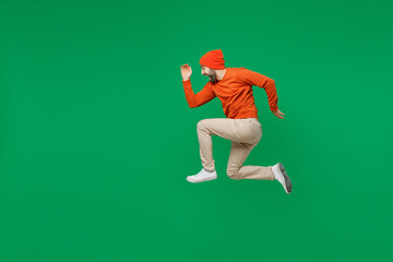 Full body side view young smiling sporty hurrying happy caucasian man 20s wear orange sweatshirt...