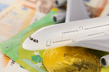 Bitcoin, euro and airplane close up