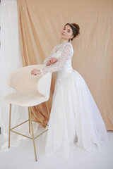 girl in a white wedding retro dress. wedding dress and hairstyle in the style of the 90's. Studio photo shoot in my mother's wedding dress. Bride photo shoot in the studio