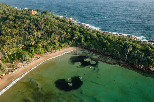 Aerial view of local fishermen in traditional wooden boats fishing near Dickwella beach.