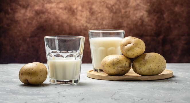 vegan potato milk in glass and raw potato. Alternative plant based milk. superfood concept. Healthy, clean eating. Vegan or gluten free diet. banner, menu, recipe place for text