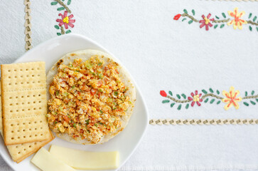 Colombian breakfast. Arepa (ground corn flour dough),egg with traditional sauce called hogado(stir-fried tomato and onion), with crackers and cheese,on light background with copy space.Flatlay