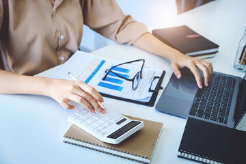 economists and accountants , data analysts are using calculators to calculate budgets and investments using statistical documents and computers to work at their desks.