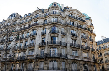 The facade of traditional French house with typical balconies and windows. Paris.