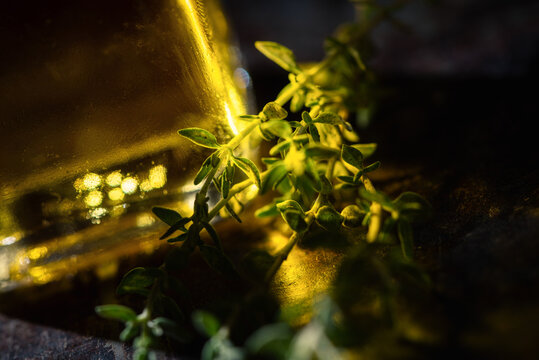 Thyme near glass of olive oil