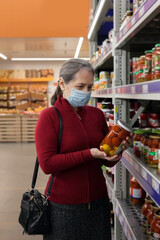Senior woman wearing face mask shopping in supermarket