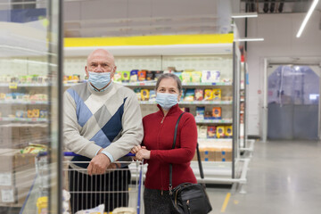 Pensioners in protective masks choosing products in supermarket