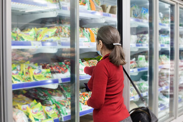 Senior woman wearing face mask shopping in supermarket